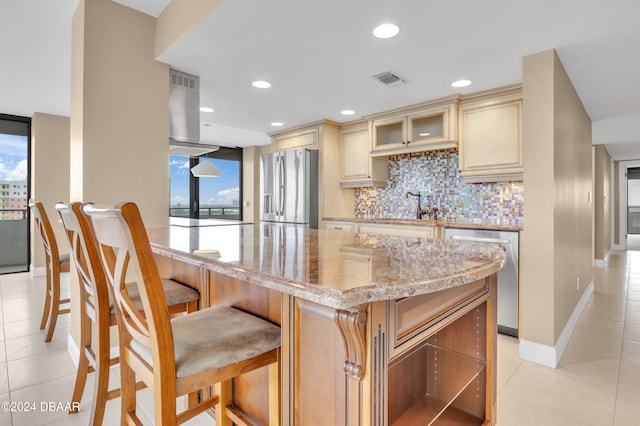 kitchen featuring a wealth of natural light, stainless steel appliances, light stone counters, and backsplash