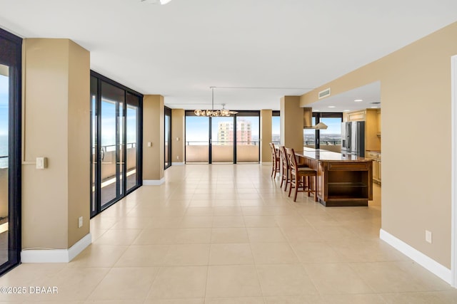 2200 N Atlantic Ave Unit 1602, Daytona Beach, FL 32118 - dining area featuring light tile patterned flooring, floor to ceiling windows, baseboards, visible vents, and an inviting chandelier