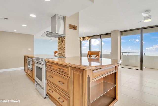 kitchen with range hood, appliances with stainless steel finishes, decorative light fixtures, and a healthy amount of sunlight