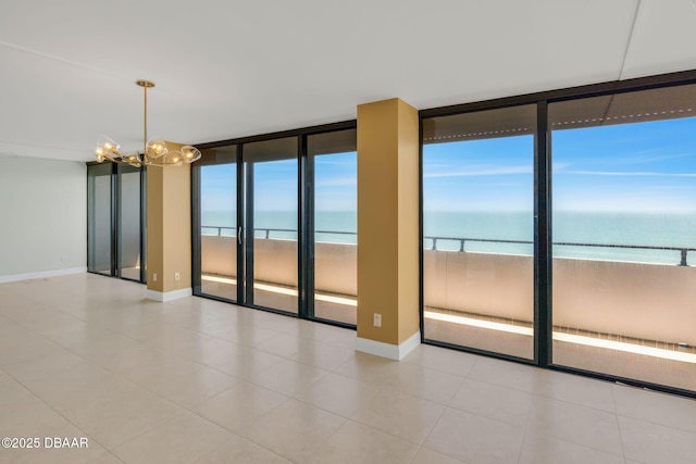 2200 N Atlantic Ave Unit 1602, Daytona Beach, FL 32118 - unfurnished room featuring a wealth of natural light, a water view, a chandelier, and a wall of windows