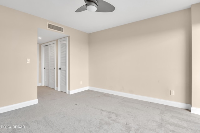 spare room with ceiling fan and light carpet