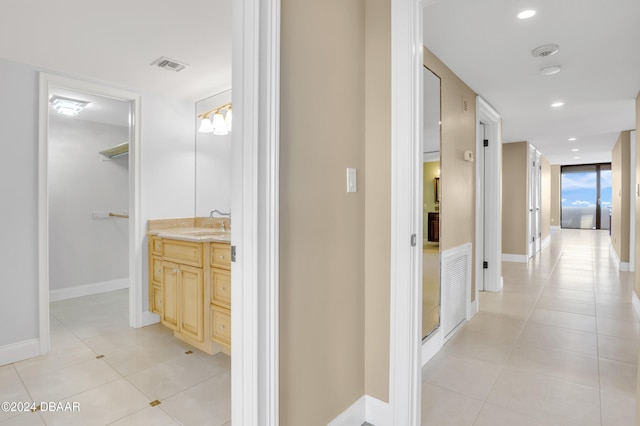 corridor featuring sink and light tile patterned floors