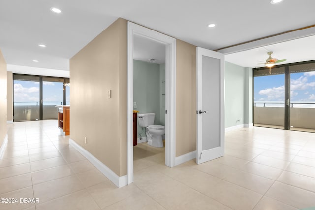 hallway featuring expansive windows and light tile patterned floors