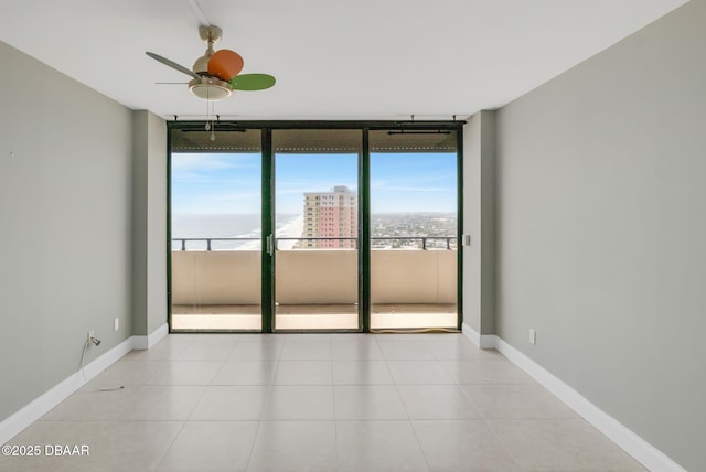 2200 N Atlantic Ave Unit 1602, Daytona Beach, FL 32118 - tiled empty room with a ceiling fan, baseboards, and a wall of windows