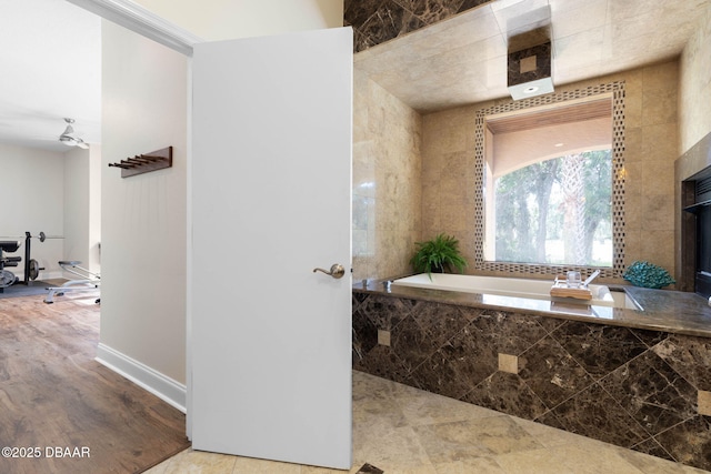 bathroom with a bath and baseboards