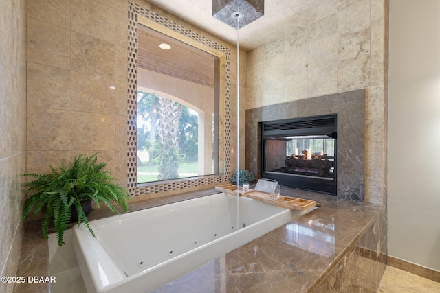 bathroom featuring baseboards, a wealth of natural light, a jetted tub, and a multi sided fireplace