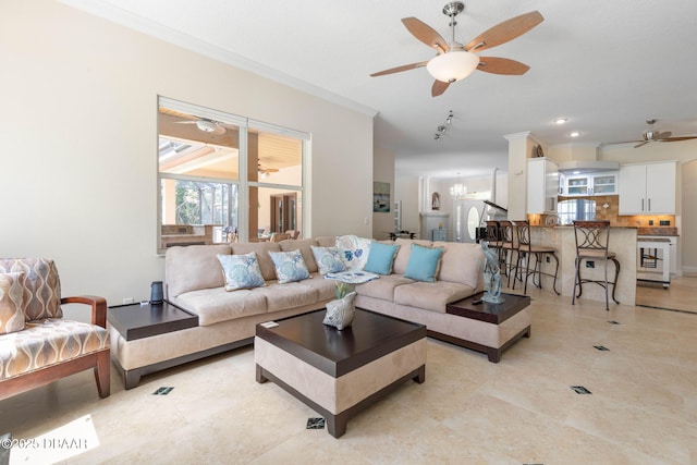 living room featuring light tile patterned floors, a ceiling fan, and ornamental molding
