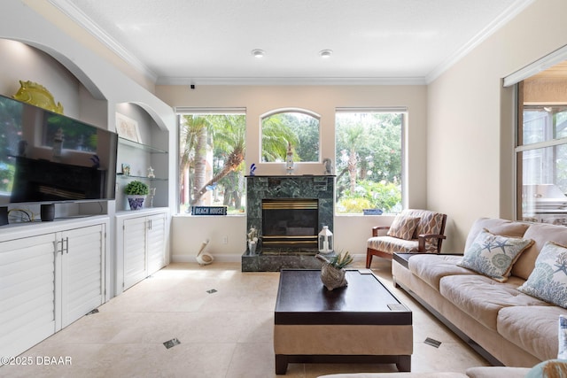 living room with tile patterned floors, crown molding, baseboards, built in shelves, and a high end fireplace