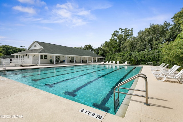 community pool with a patio and fence