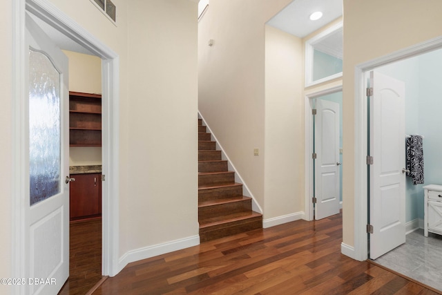 foyer featuring stairs, baseboards, visible vents, and wood finished floors