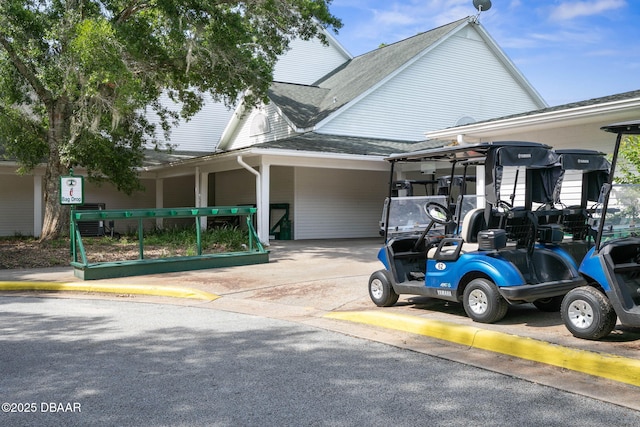 view of property exterior featuring a shingled roof, driveway, and an attached carport