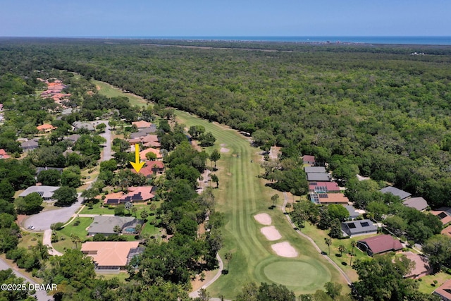 drone / aerial view featuring a residential view, golf course view, and a view of trees