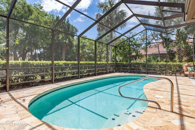 view of pool featuring a patio area, a fenced in pool, and glass enclosure