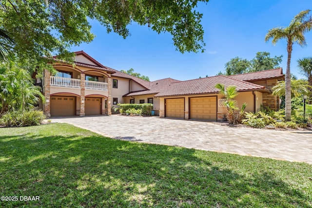 mediterranean / spanish-style home with stucco siding, a tiled roof, and a front yard