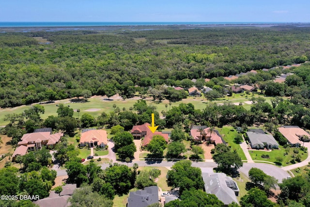 aerial view with view of golf course, a wooded view, and a residential view