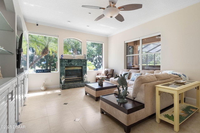 living area with a wealth of natural light, ornamental molding, a fireplace, and ceiling fan
