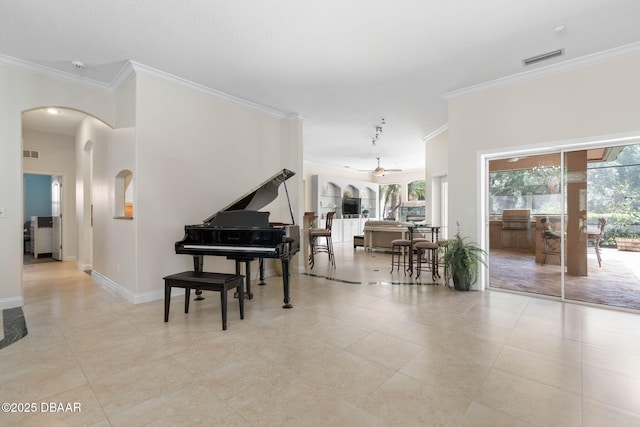 interior space featuring arched walkways, ornamental molding, visible vents, and baseboards