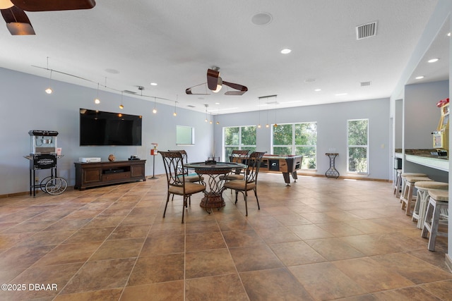recreation room with visible vents, tile patterned flooring, a ceiling fan, and arched walkways