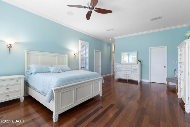 bedroom featuring crown molding, a warm lit fireplace, and wood finished floors