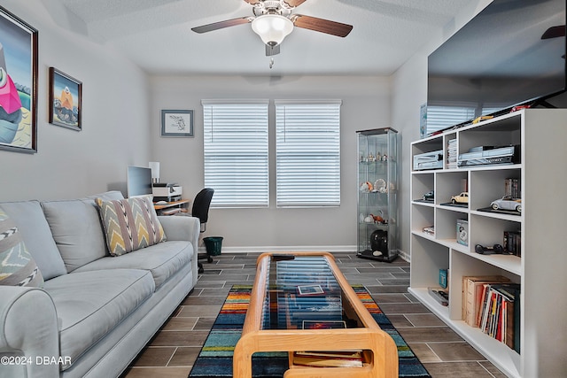 living room with a textured ceiling and ceiling fan