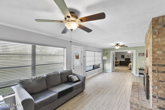 living room featuring ceiling fan, light hardwood / wood-style floors, crown molding, and a wealth of natural light