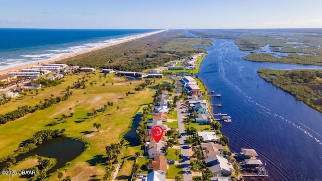 birds eye view of property with a water view and a beach view