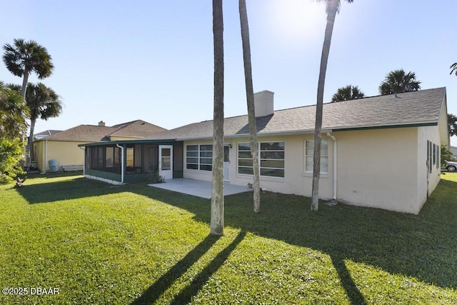 back of property featuring a lawn, a sunroom, and a patio area