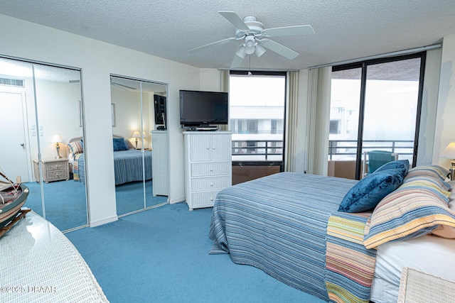 carpeted bedroom featuring multiple closets, ceiling fan, access to outside, and a textured ceiling