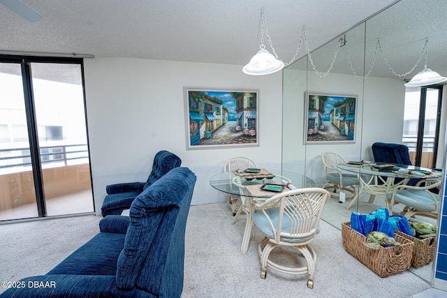 living room with carpet, a textured ceiling, and a wall of windows