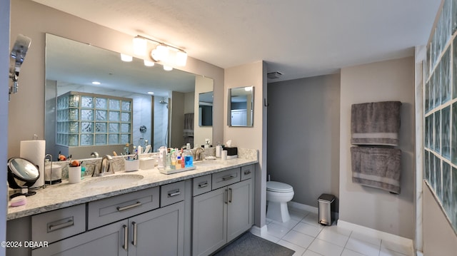 bathroom featuring vanity, a shower with door, tile patterned floors, and toilet