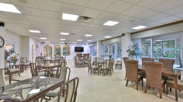 dining space featuring a paneled ceiling and plenty of natural light