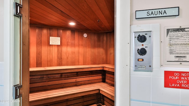 view of sauna / steam room featuring wood ceiling and wooden walls