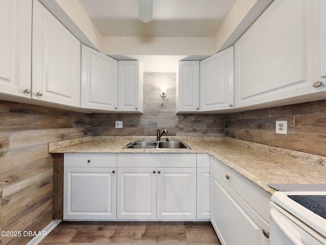 kitchen featuring white cabinetry, sink, dark hardwood / wood-style flooring, and white range with electric stovetop