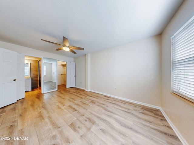 unfurnished bedroom with a spacious closet, light hardwood / wood-style floors, a closet, and ceiling fan