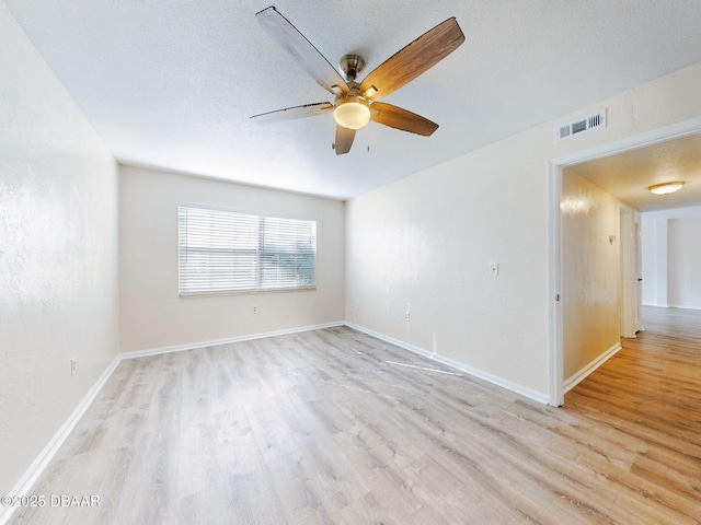 empty room featuring ceiling fan, light hardwood / wood-style flooring, and a textured ceiling