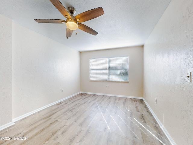 spare room with a textured ceiling, light hardwood / wood-style floors, and ceiling fan