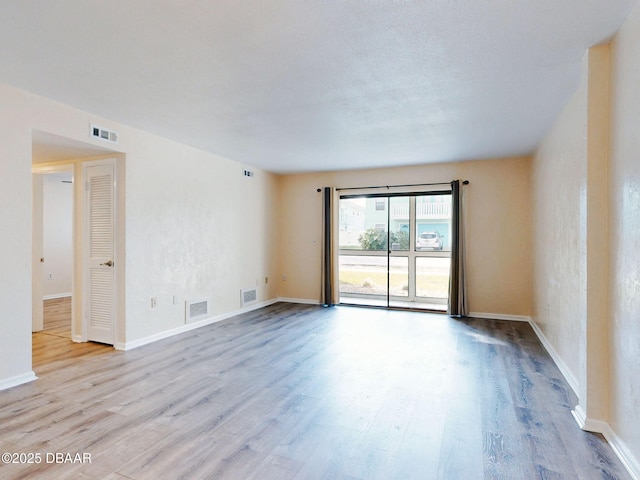 empty room featuring light hardwood / wood-style floors and a textured ceiling