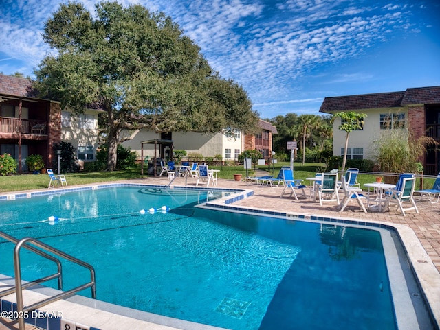 view of swimming pool with a patio area and a lawn