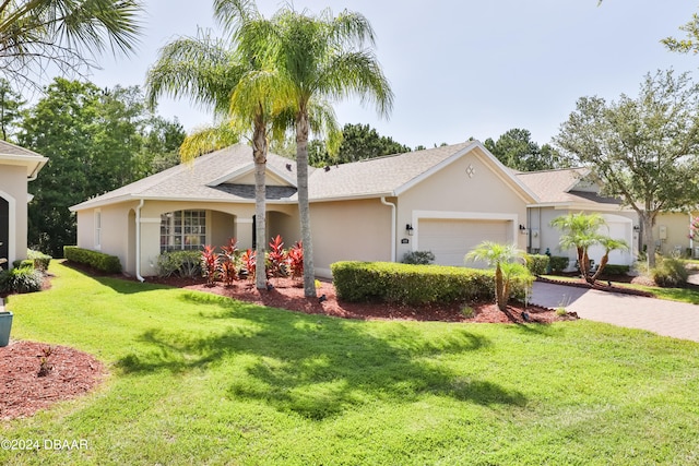 ranch-style house featuring a garage and a front lawn