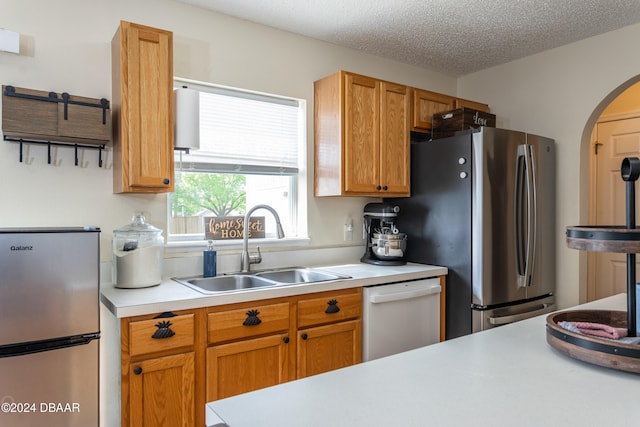 kitchen featuring a textured ceiling, sink, and stainless steel appliances