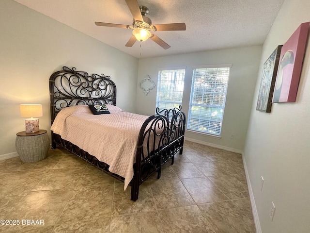 bedroom featuring a textured ceiling, baseboards, and a ceiling fan