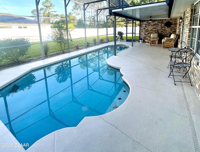 view of pool featuring glass enclosure, fence, a fenced in pool, and a patio area