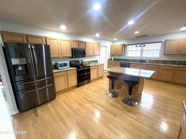 kitchen featuring dishwashing machine, double oven range, a sink, refrigerator with ice dispenser, and light wood-type flooring