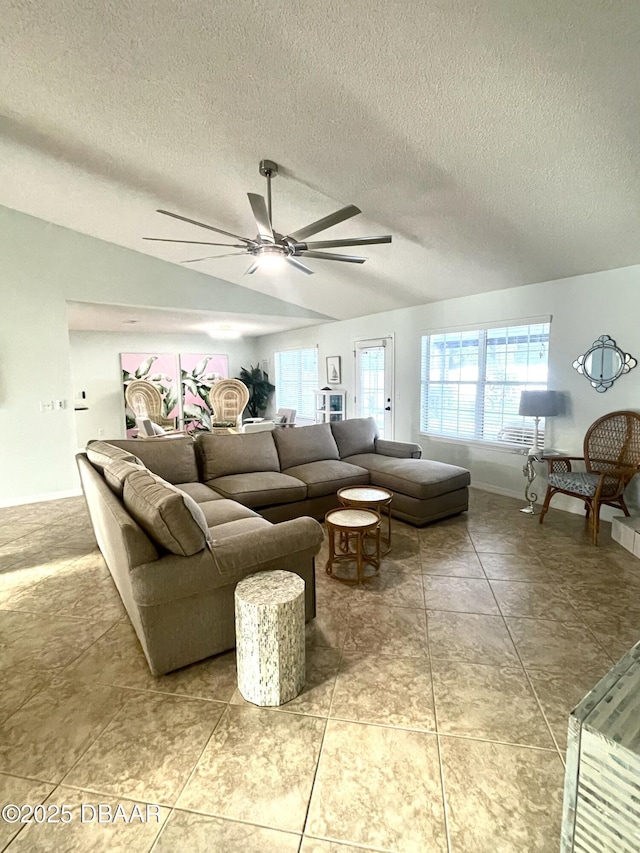 living room featuring a ceiling fan, a wealth of natural light, and a textured ceiling