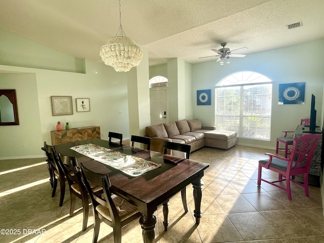 tiled dining room with ceiling fan with notable chandelier, baseboards, visible vents, and a textured ceiling