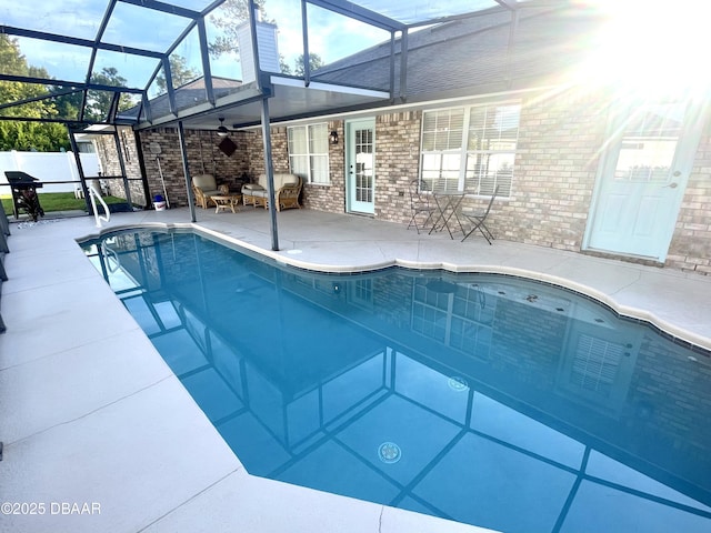 view of pool with glass enclosure, fence, a patio area, and a fenced in pool