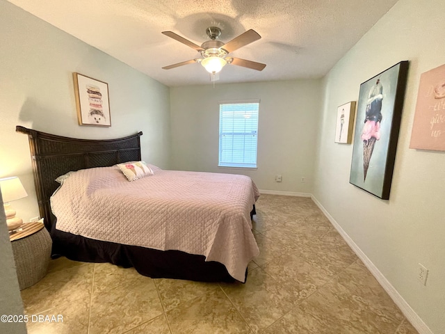 bedroom with a textured ceiling, baseboards, and a ceiling fan