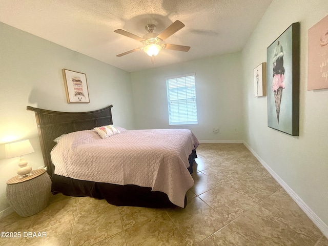 bedroom featuring ceiling fan, a textured ceiling, and baseboards