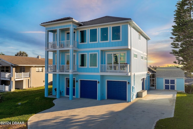 view of front of home with a garage, a storage unit, a lawn, and a balcony