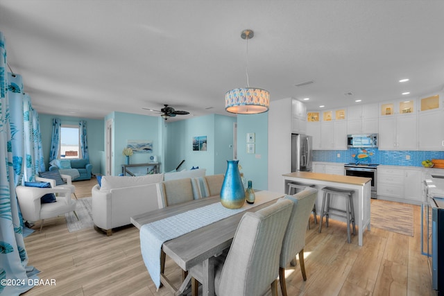 dining area featuring light hardwood / wood-style flooring and ceiling fan